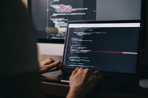 Developer working on a laptop, integrating Mocean SMS API for secure and scalable messaging in Indonesia.